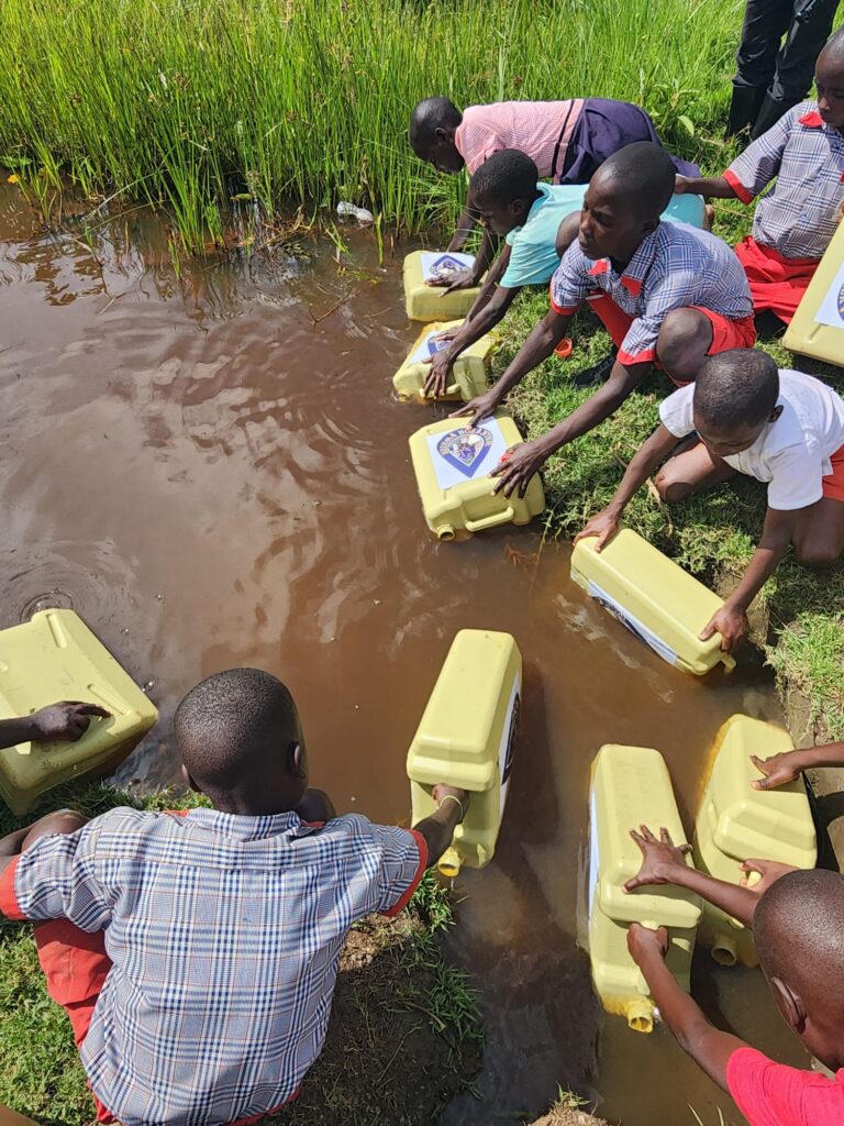 Children filling water canisters during annual Walk for Water event Uganda