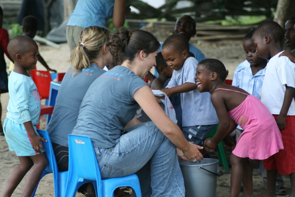 Youths As Volunteers Integrated Network Society volunteers helping children wash their hands Uganda