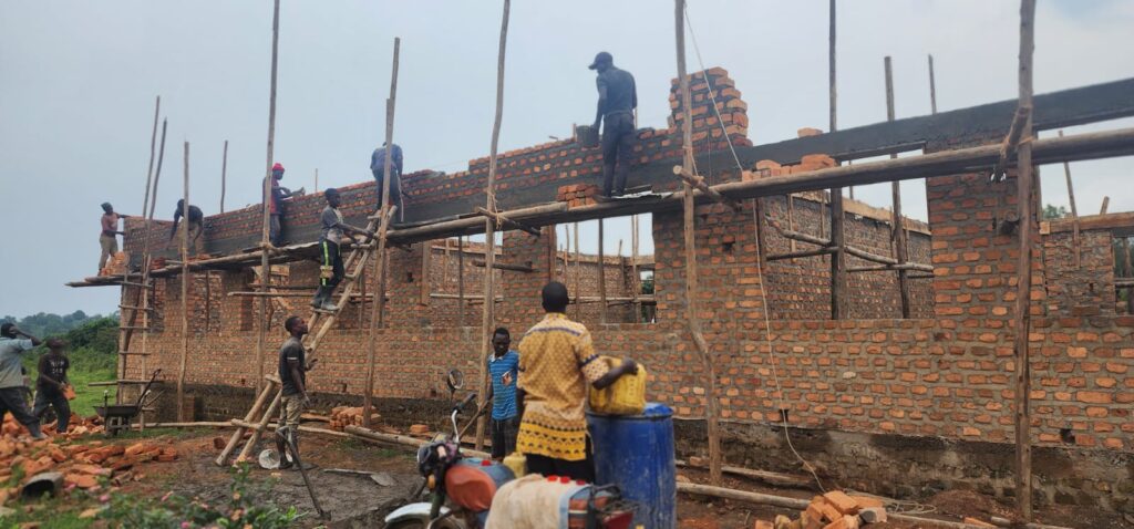 Workers on scaffolding laying bricks for main building YAVINS Education Centre Uganda